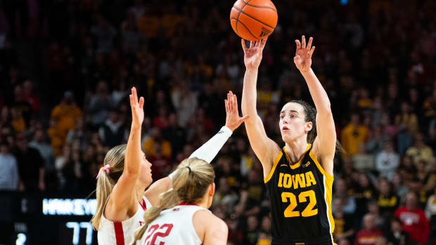 Iowa Hawkeyes guard Caitlin Clark (22) shoots a three point shot against Nebraska Cornhuskers guard Jaz Shelley (1) and forward Natalie Potts (22) during the fourth quarter at Pinnacle Bank Arena.